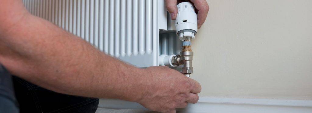 plumber adjsuting radiator